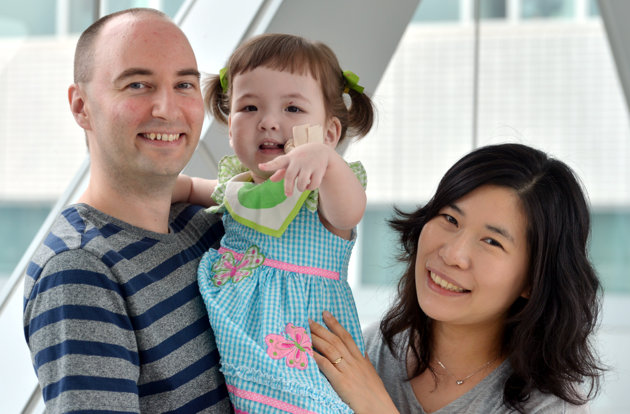 Associated Press/The Korea Herald, Kim Myung-sub - In this July 13, 2012 photo, Hannah Warren, 2, poses with her parents Lee Young-mi and Darryl Warren at Seoul National University Hospital in Seoul, South Korea. Hannah received a new windpipe made from her own stem cells in a landmark operation on April 9, 2013, at Children's Hospital of Illinois in Peoria, Ill. She is the youngest patient ever to get the experimental treatment. Hannah was born without a windpipe and her doctors in South Korea expected her to die, but doctors in Illinois said Tuesday, April 30, 2013, she is recovering and likely will lead a normal life. (AP Photo/The Korea Herald, Kim Myung-sub)